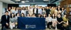 A group of Alumni holding the University of Glasgow flag in a conference room