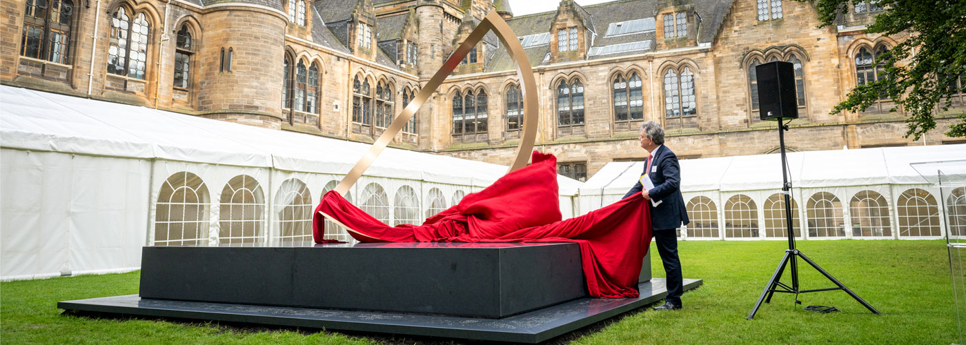 The principal unveiling the alma mater sculpture on the east quads