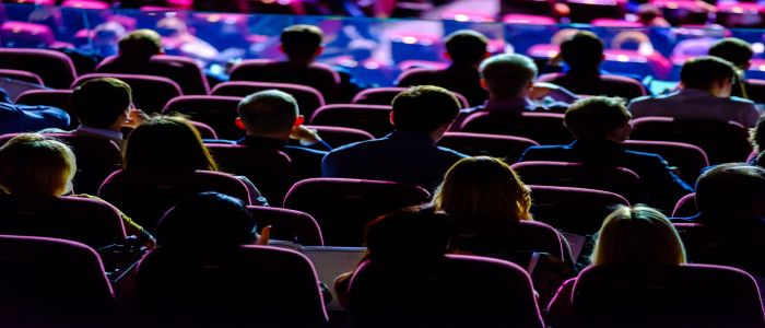 Audience at a conference looking at a stage