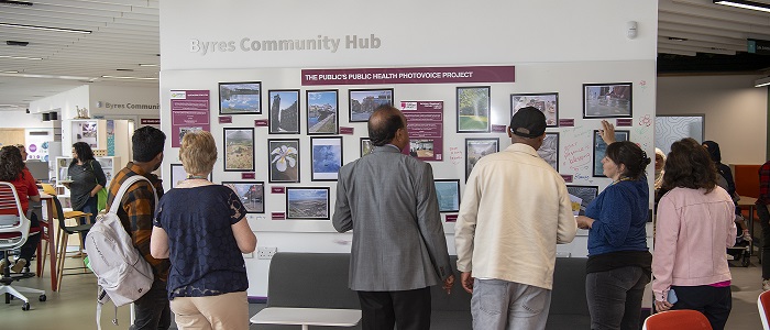 An image of people viewing the Byres Community Hub Photovoice at the launch